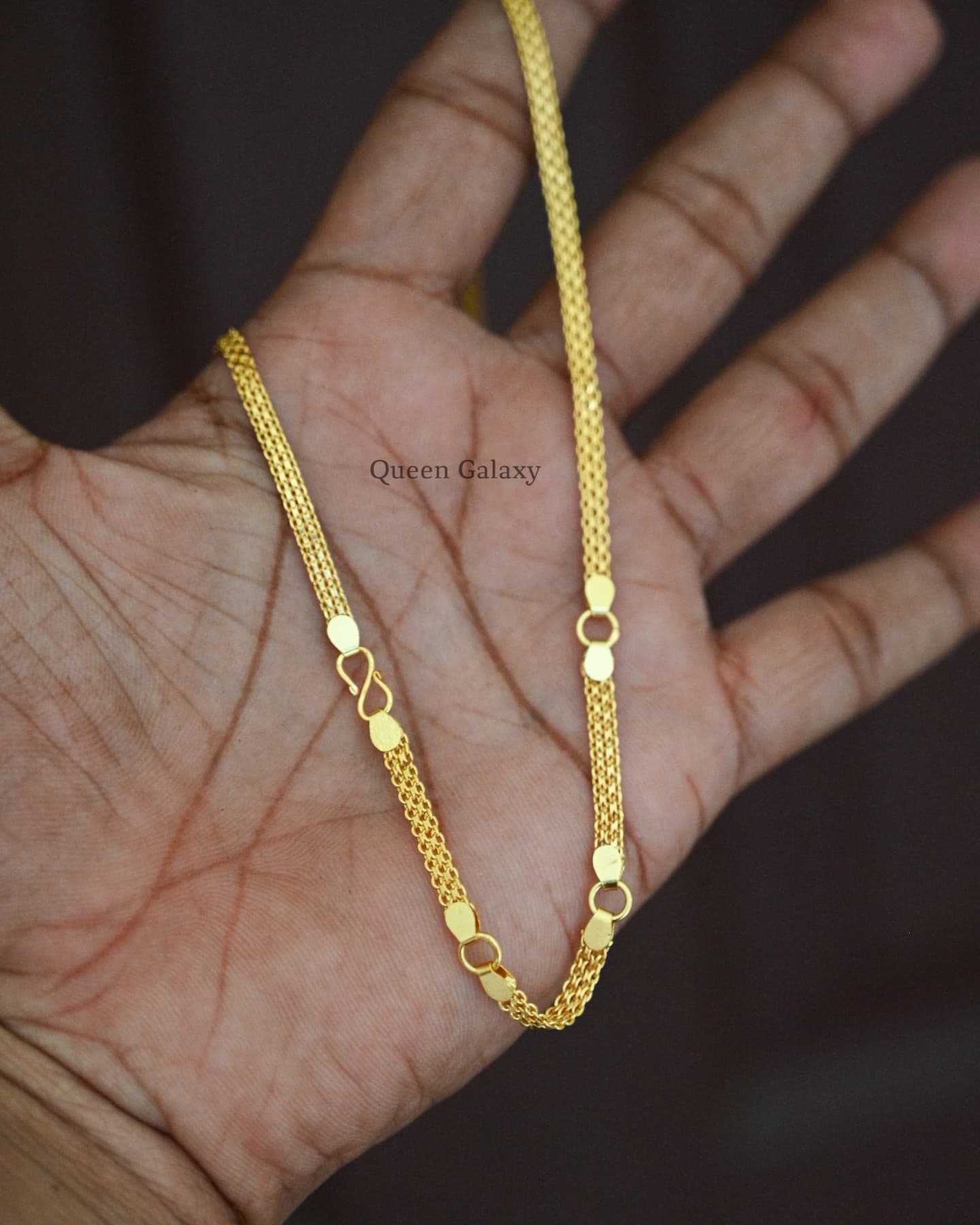 1 gram gold plated hip chain for babies laid out on a hand.