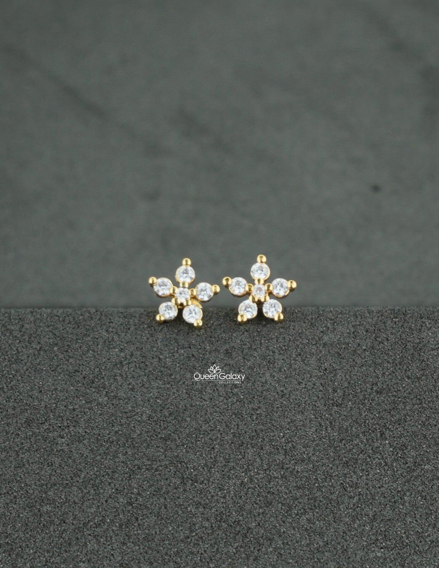 Gold plated AD stone floral nosepin and second stud on a dark textured background - queen galaxy collection