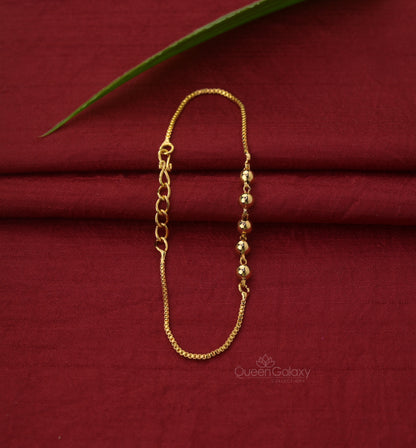 Gold Plated Beaded Chain Bracelet laid out on a red fabric surface. queen galaxy collection