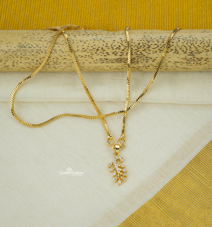 Gold plated chain with AD stone pendant placed on kasavu saree background - queen galaxy collection