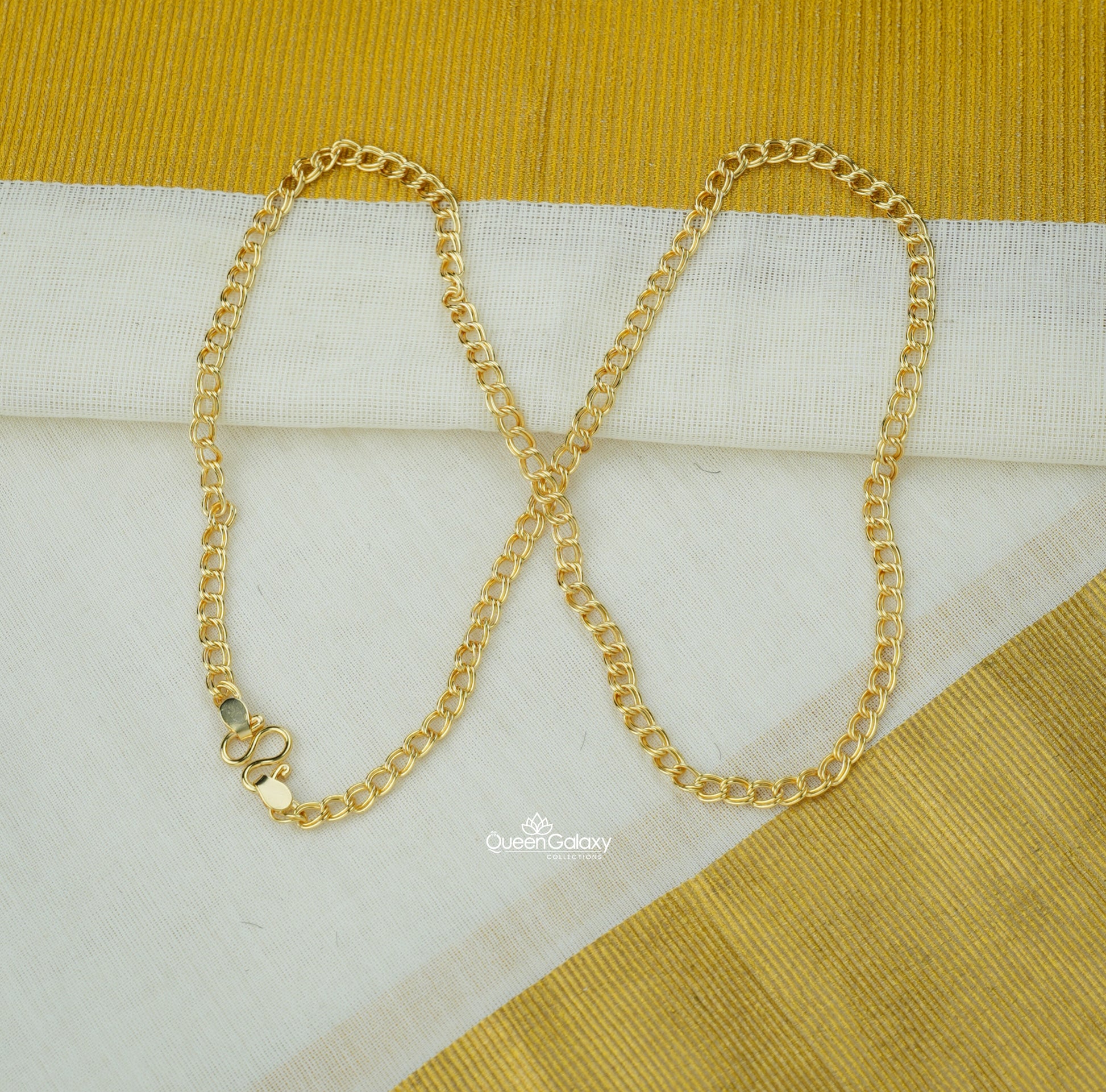 Gold plated link chain on Kerala kasavu saree background - queen galaxy collection