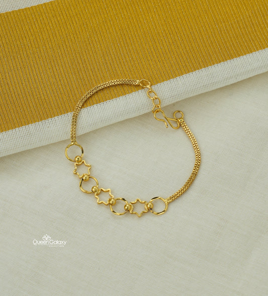 Gold Plated Star Design Bracelet on a light gray surface with a yellow fabric background