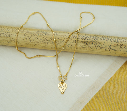 Gold Plated Hindu Thali Chain with Om Pendant on a wooden stick against a white and yellow fabric background