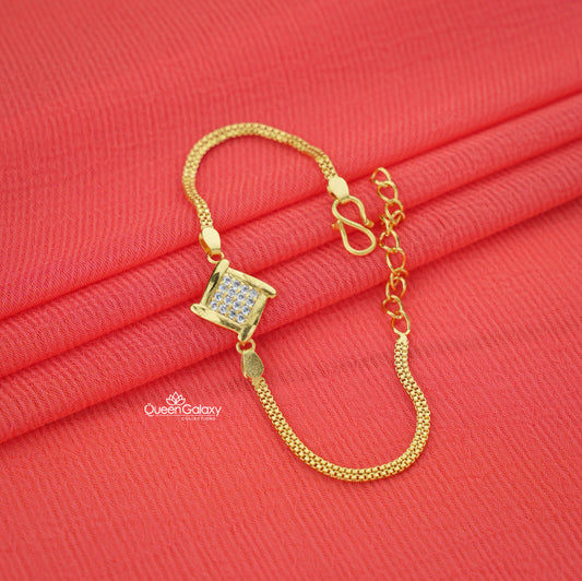 Gold bracelet with a square pendant on a red fabric background, featuring the Queen Galaxy brand.