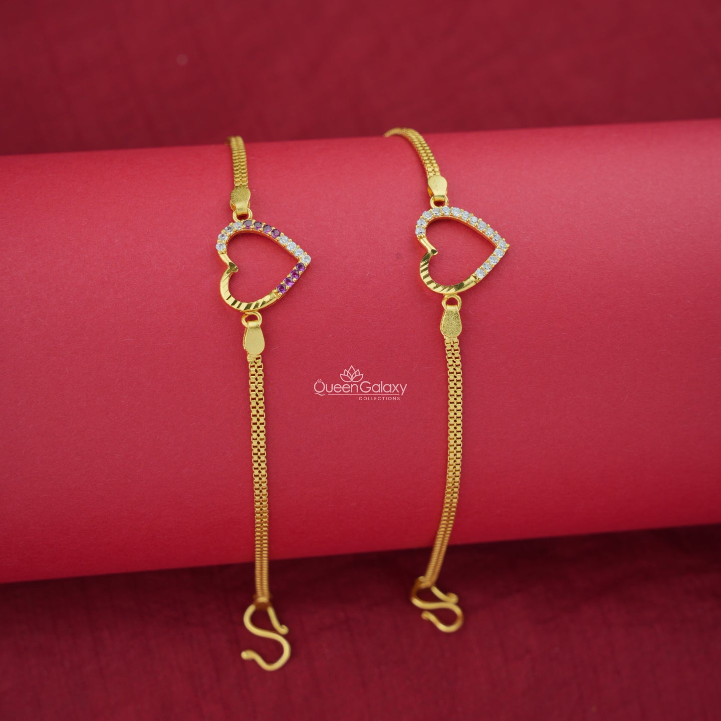 Two gold plated AD stone bracelets with heart designs on a red background, featuring the brand 'Queen Galaxy'.