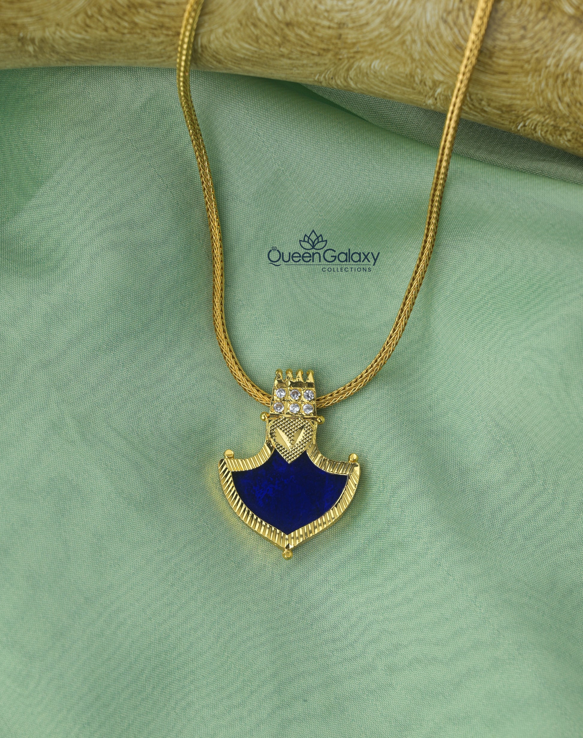 Gold plated Palakka pendant with blue stone and white accents on gold chain