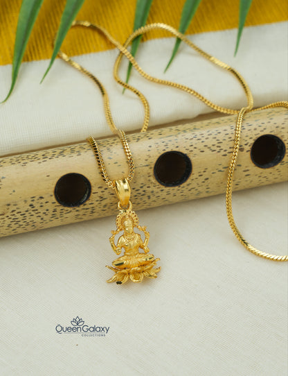 Gold plated box chain with Lakshmi Devi pendant on a white surface with a yellow fabric background- queen galaxy collection