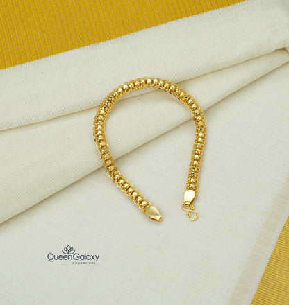 Gold bracelet on a fabric background with Queen Galaxy logo.
