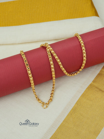 Gold plated designer chain placed on kasavu saree background with red roll - queen galaxy collection